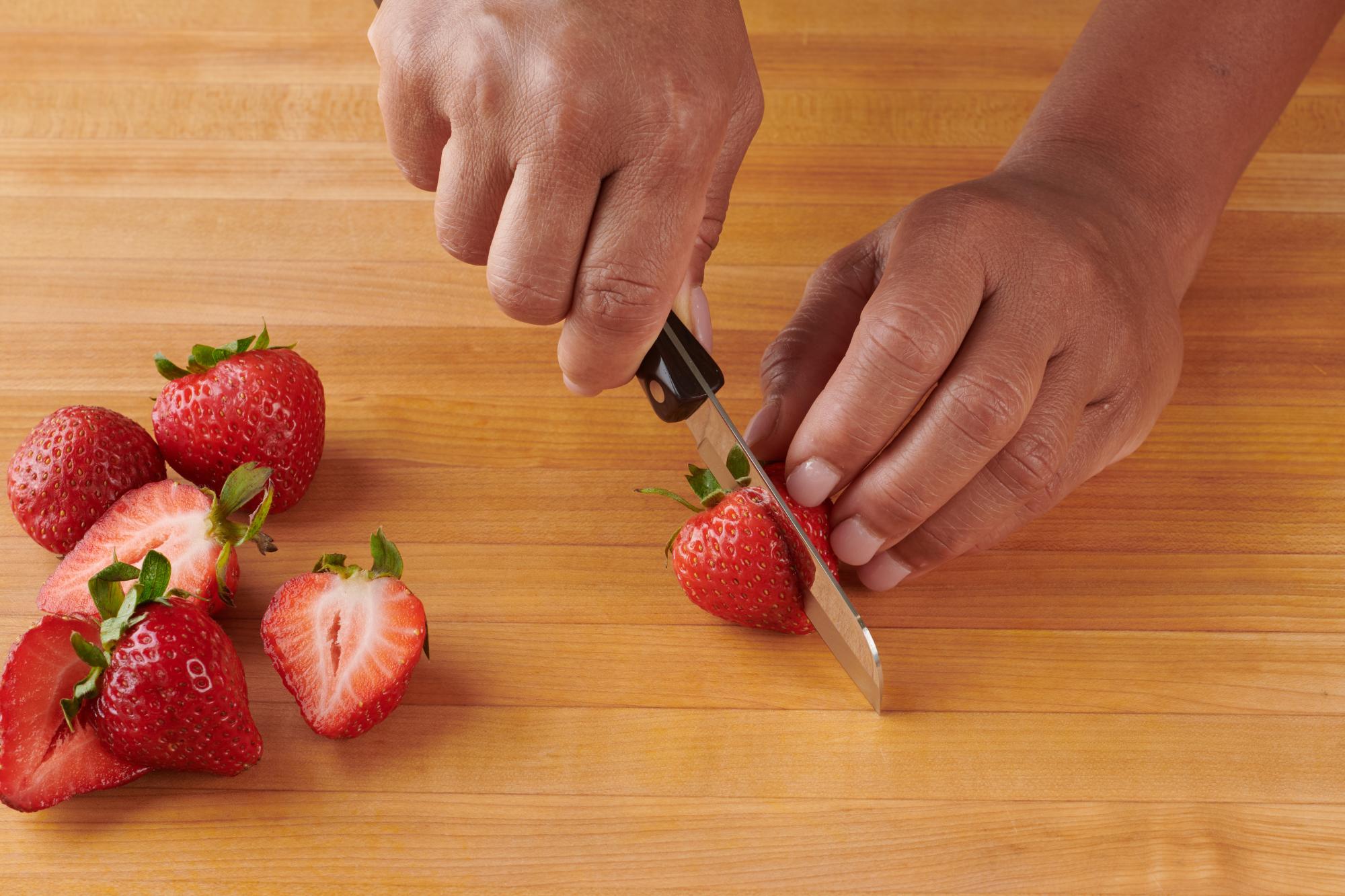Halving strawberries with a Santoku-Style 3 Inch Paring Knife.