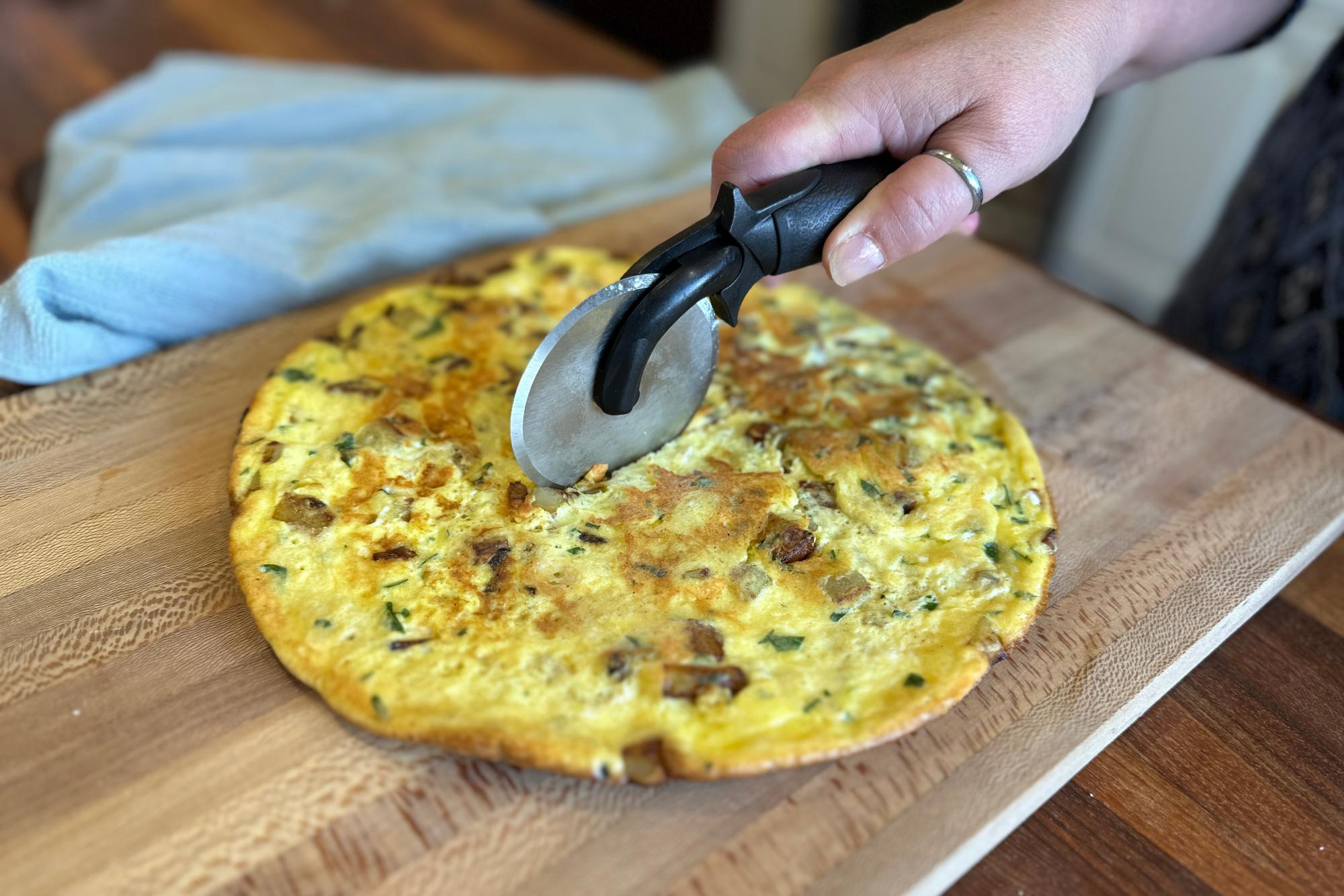 Cutting the frittata with a Pizza Cutter.