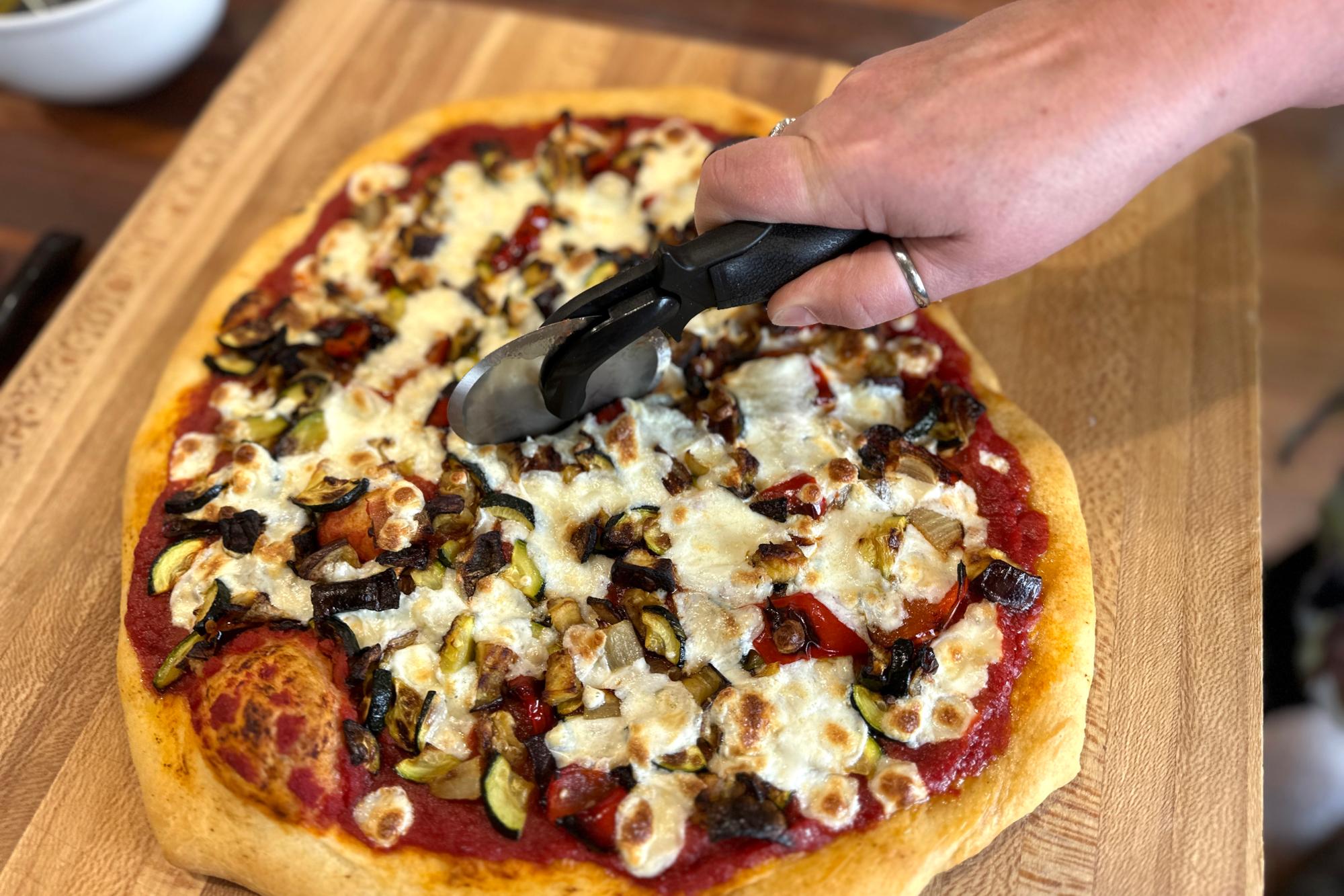 Slicing the pizza with a Pizza Cutter.