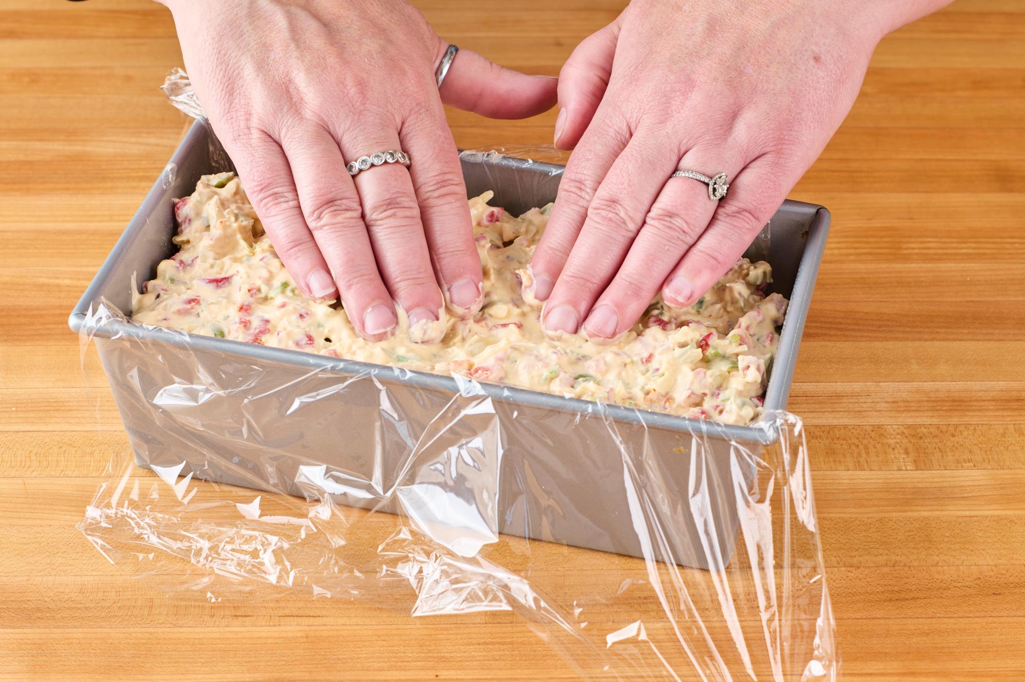 Packing the loaf pan with cheese log mixture