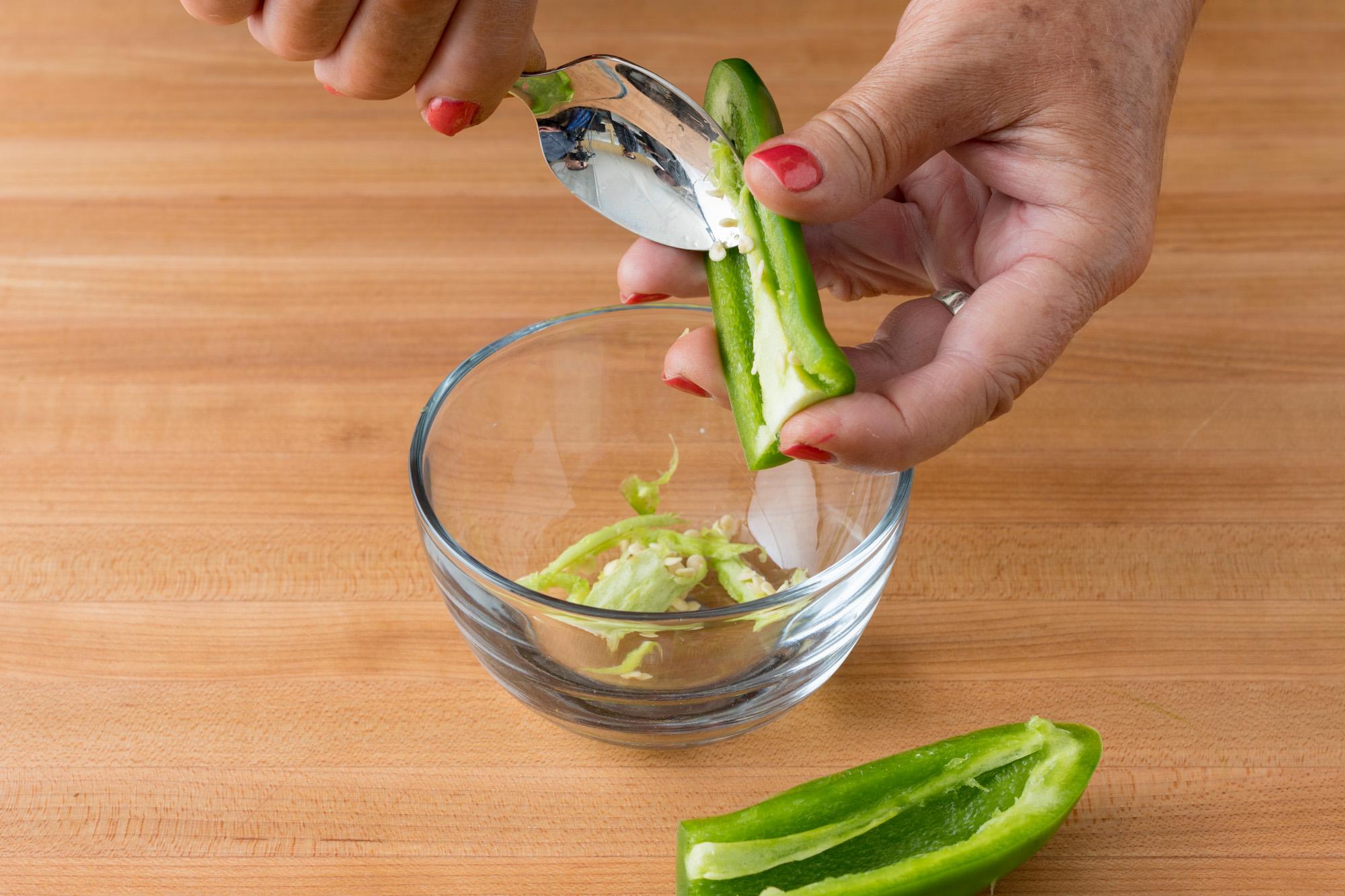 Scooping the jalapenos out with a spoon.