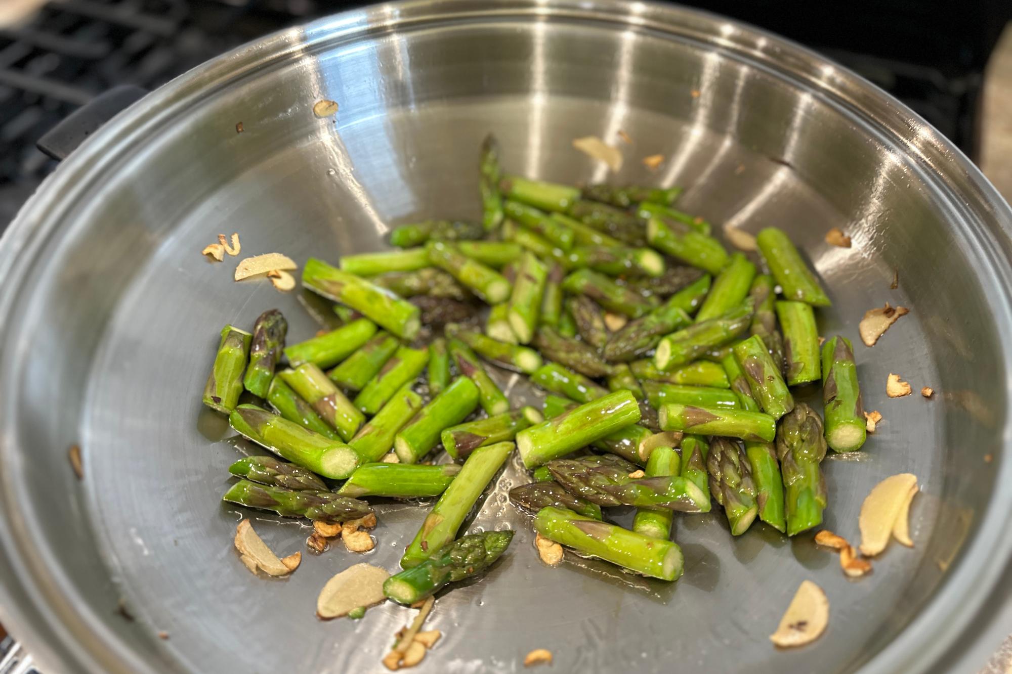 Asparagus and garlic in wok.