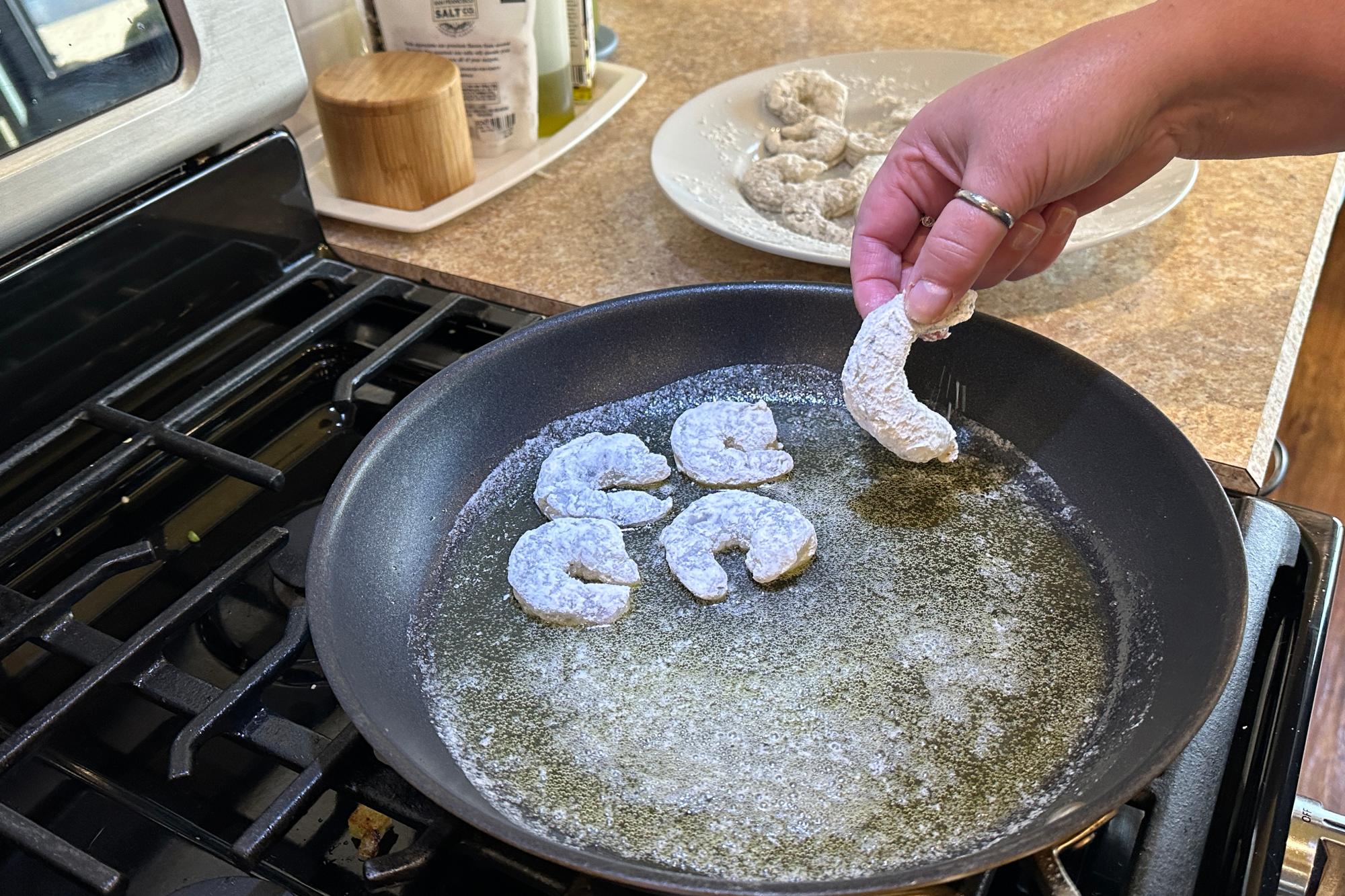 Placing shrimp in the pan.