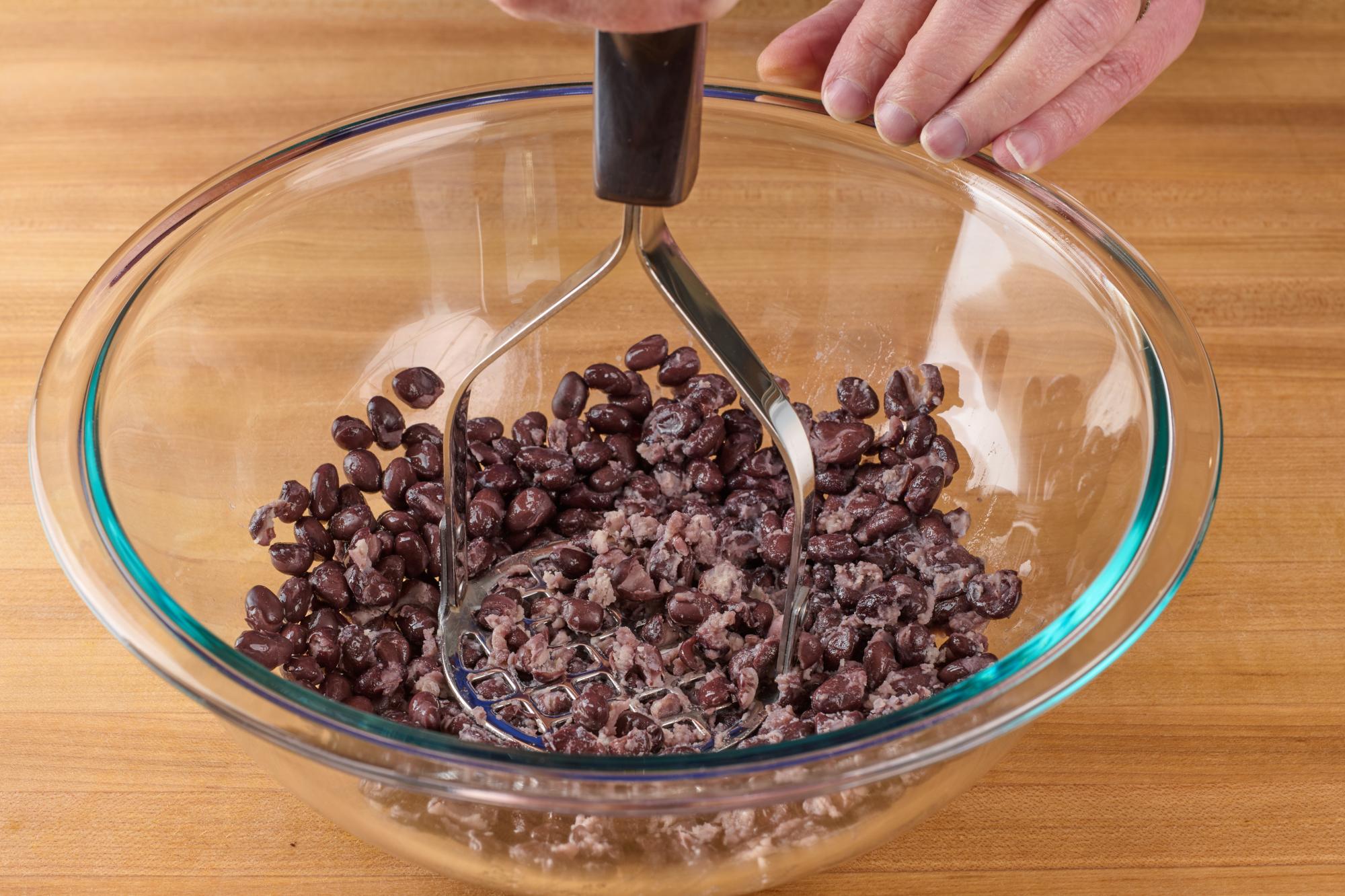 Mashing beans with Potato Masher.