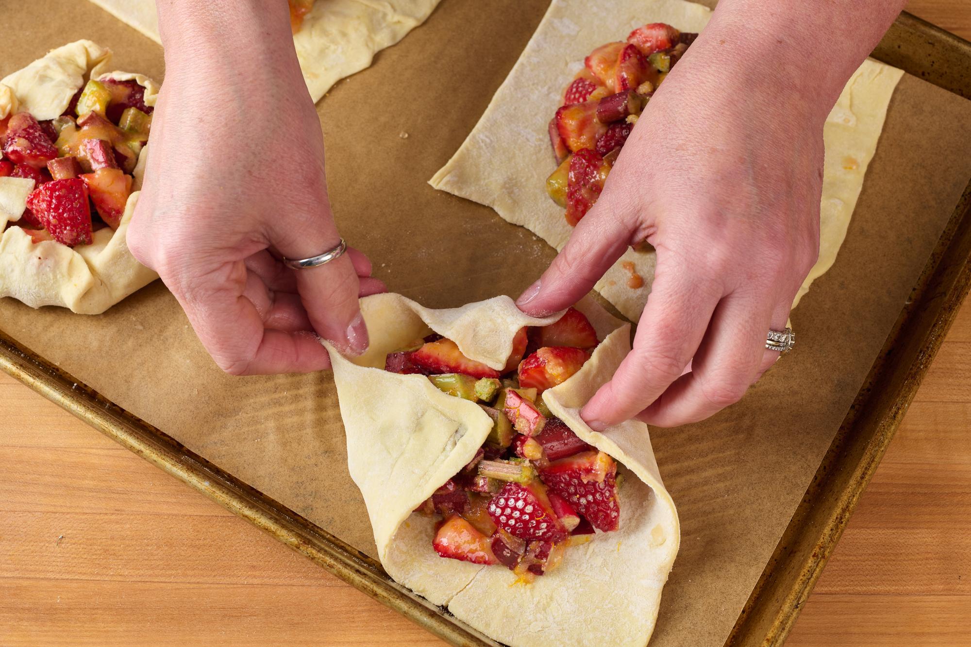 Fold the edges of each puff pastry square over the fruit filling