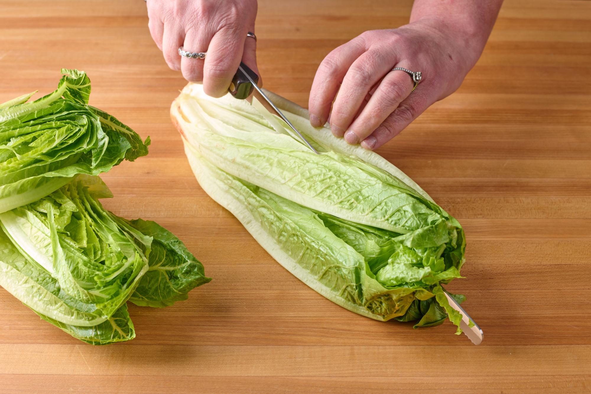 Cut the romaine hearts in half lengthwise.
