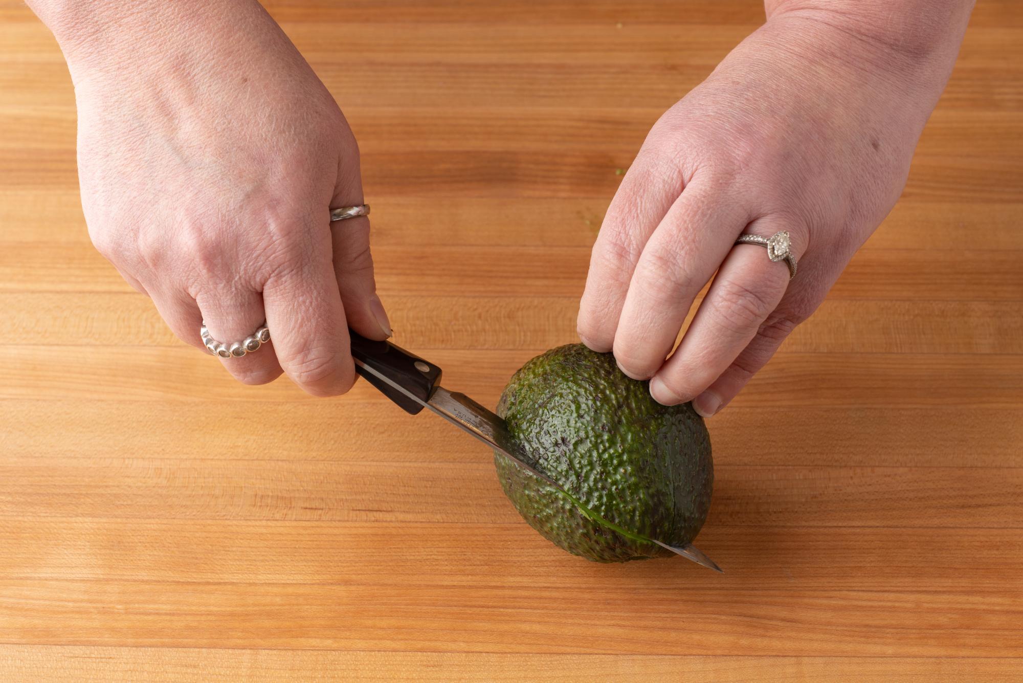 Slice the avocado in half with the 4 Inch Paring Knife.