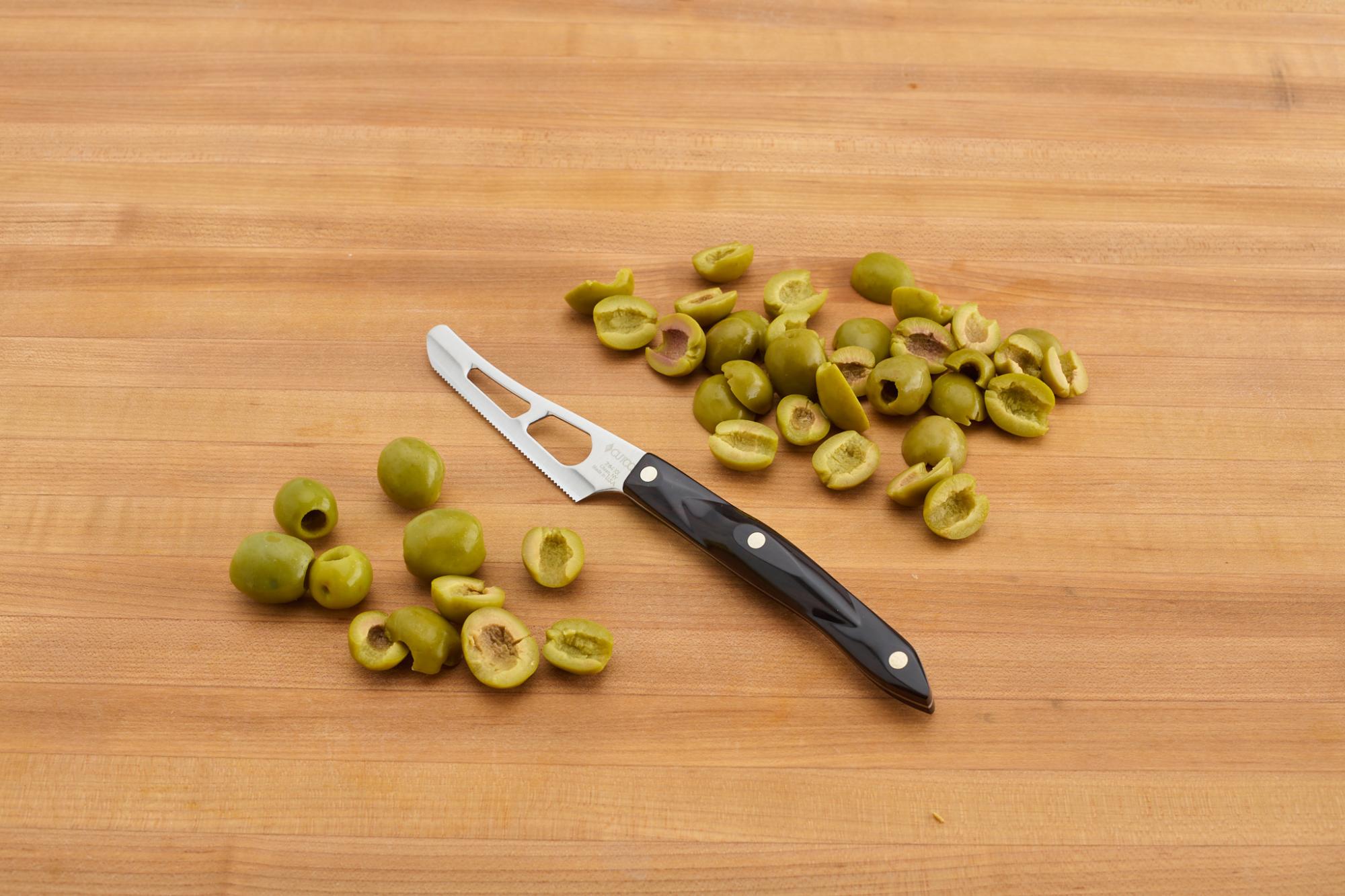 Cutting the olives in half, using a Mini Cheese Knife.