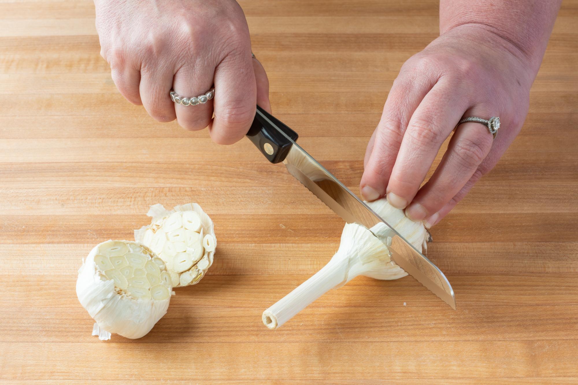 Use a Santoku-Style Trimmer to slice off the top of a bulb of garlic.