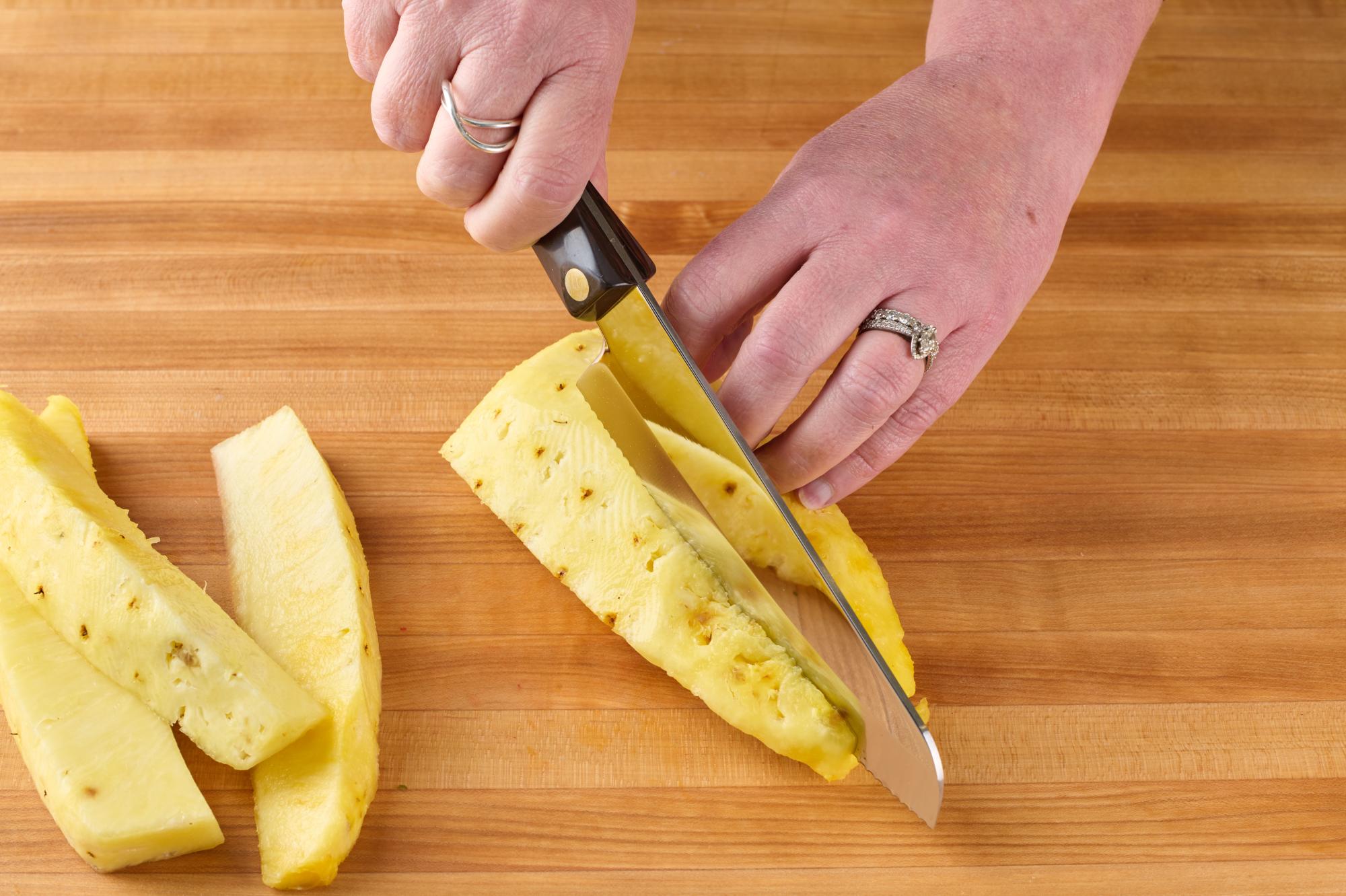 Cutting peeled, cored pineapple into long slabs with Hardy Slicer.