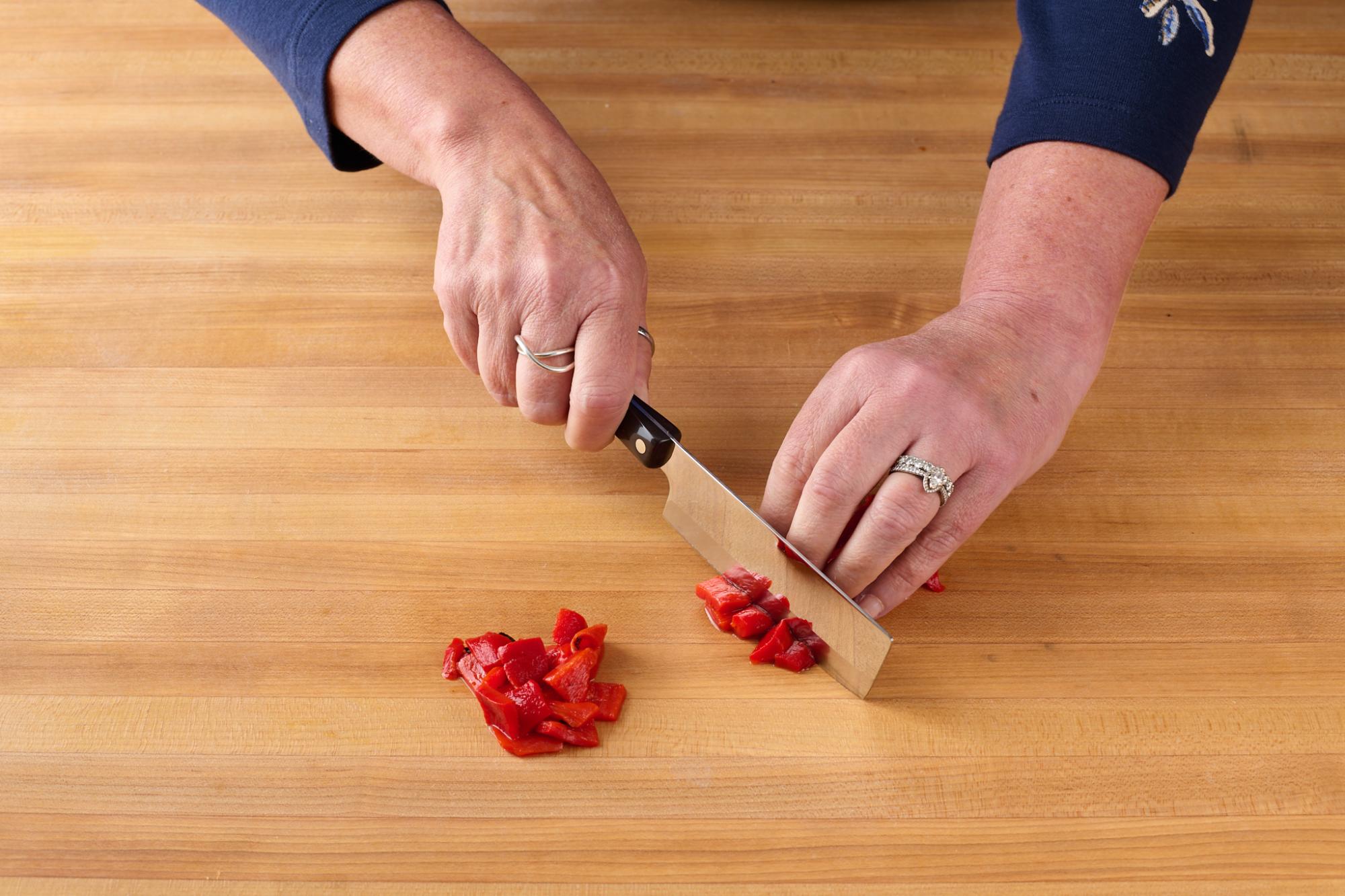 With a 4″ Vegetable Knife, roughly chop the roasted red peppers.