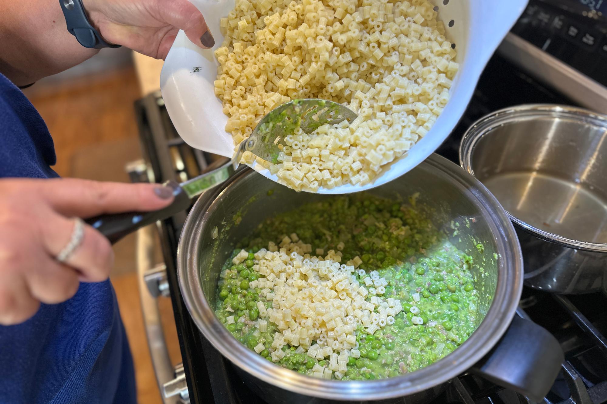 Mixing the pasta into the pea mixture.