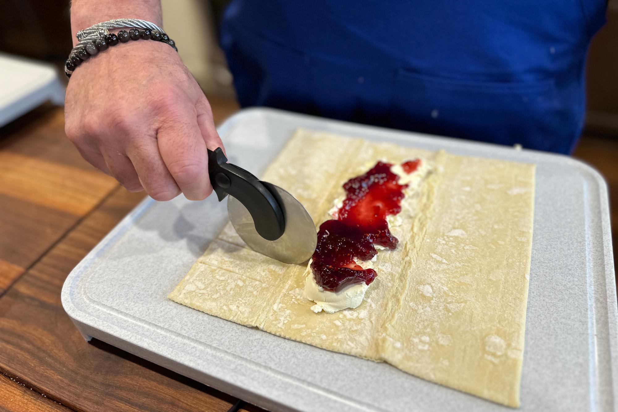 Cutting strips along the pastry with a Pizza Cutter.