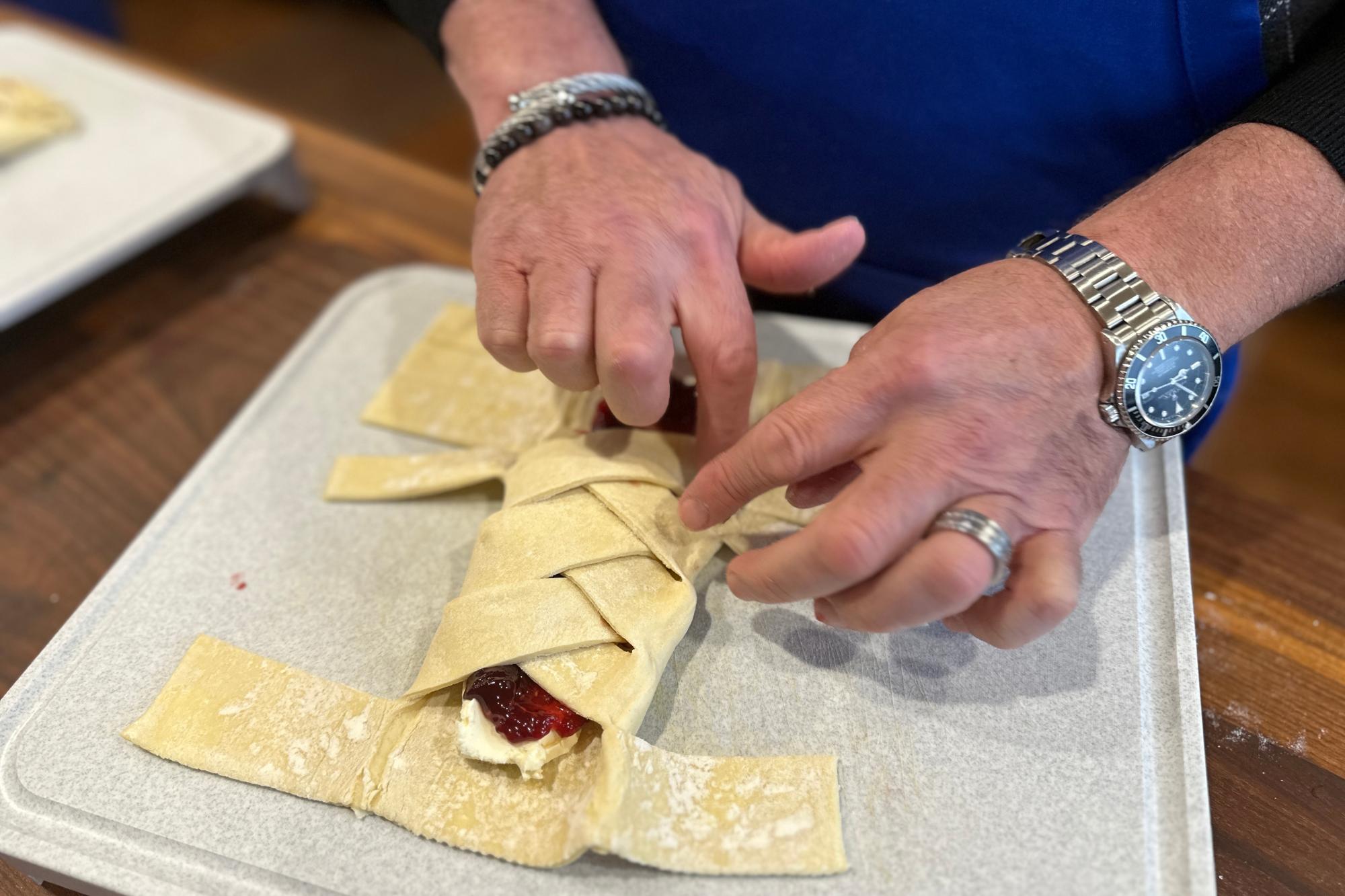 Braiding the strips of dough.