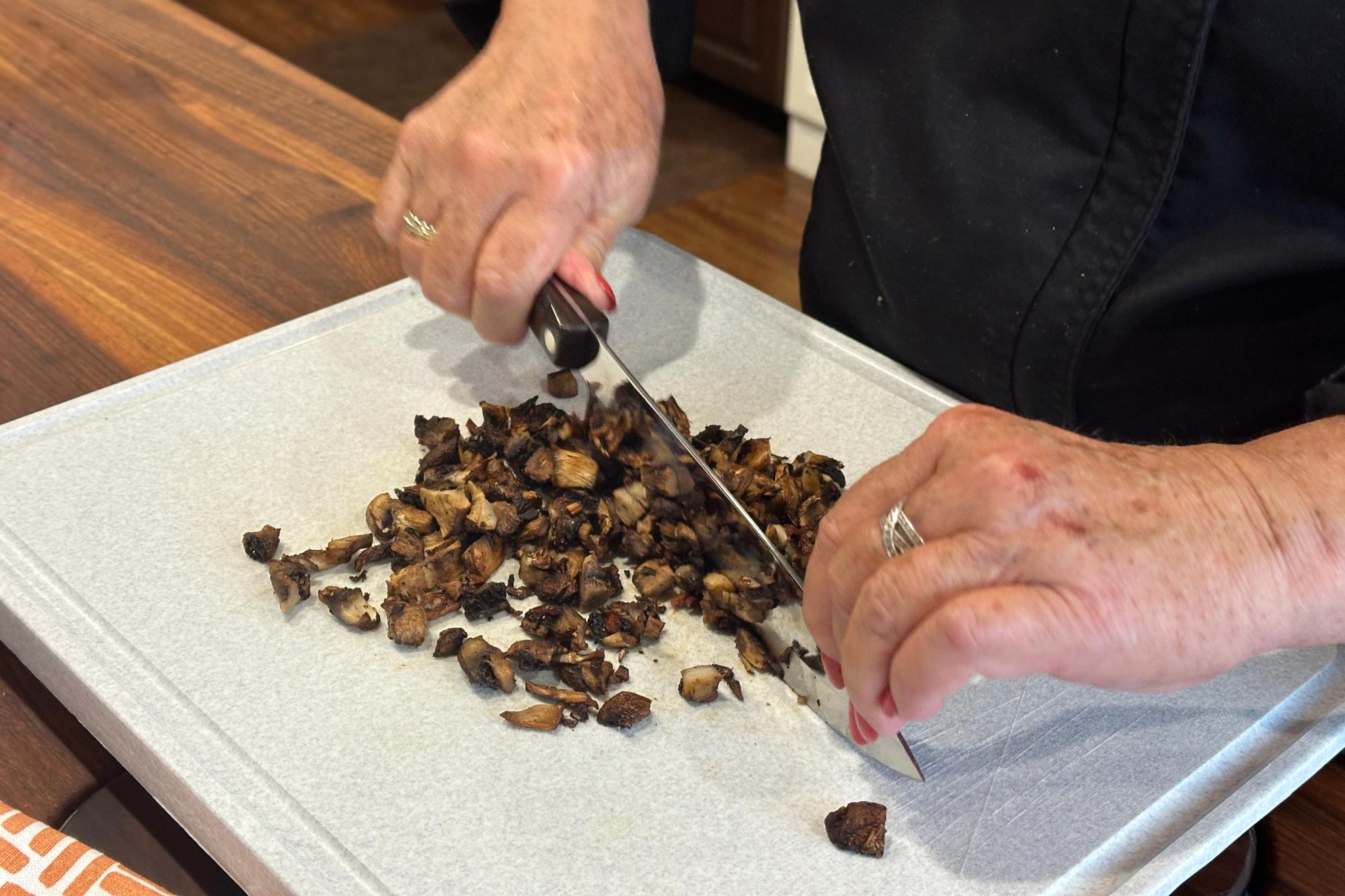 Finely dicing roasted mushrooms using Petite Chef Knife.