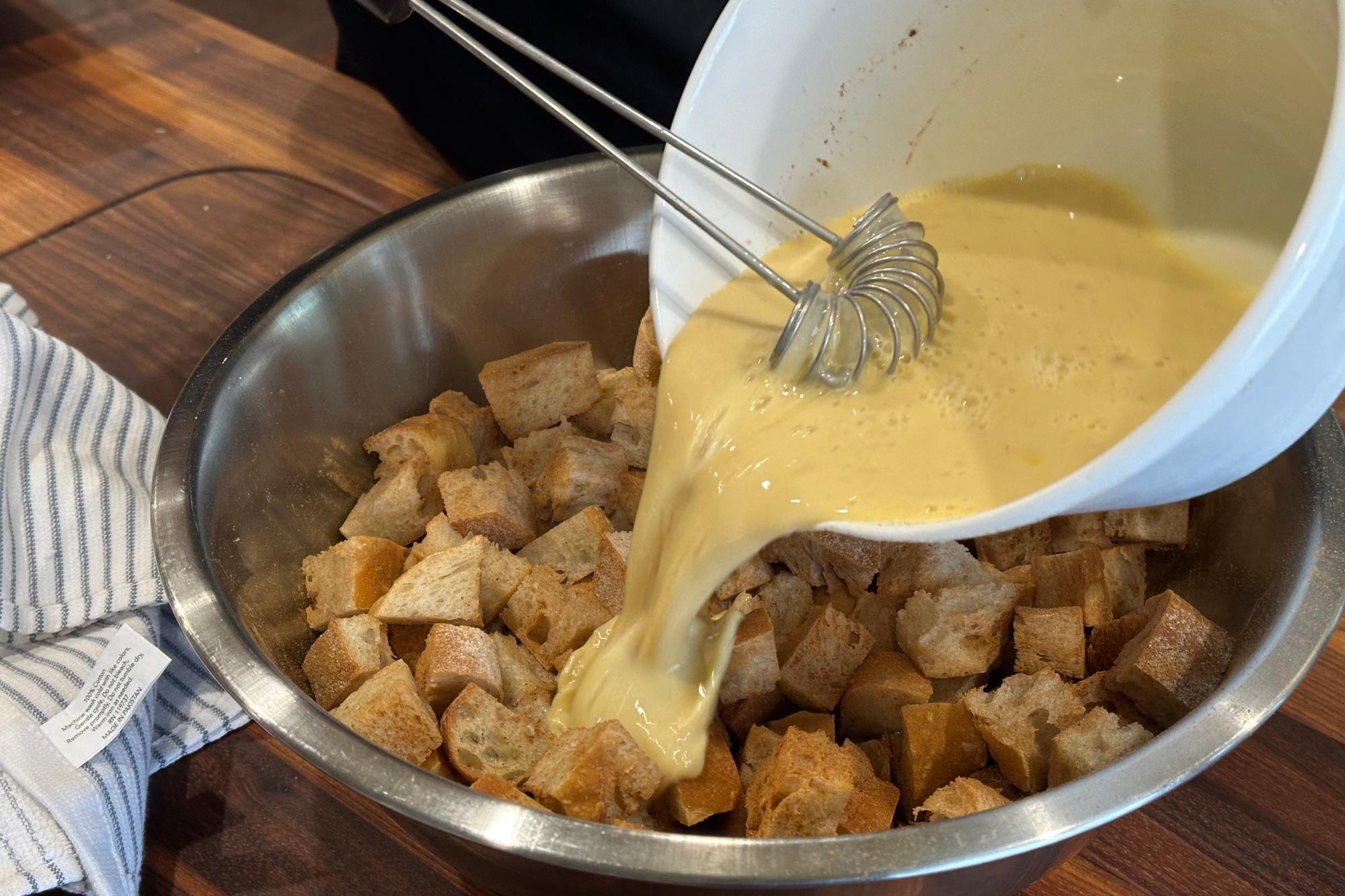 Pouring egg mixture over the bread.