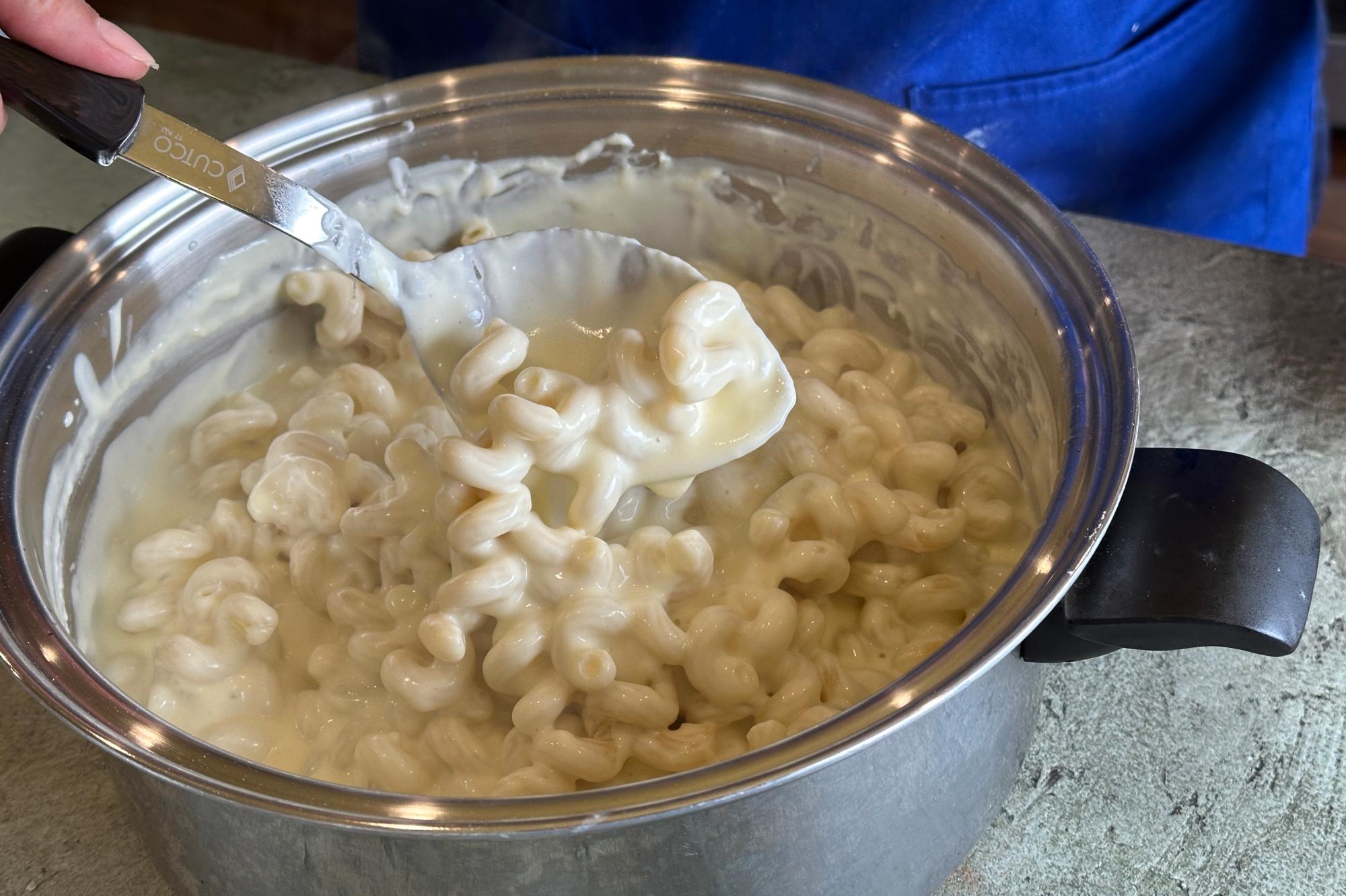 Stirring pasta into cheese mixture with Basting Spoon.