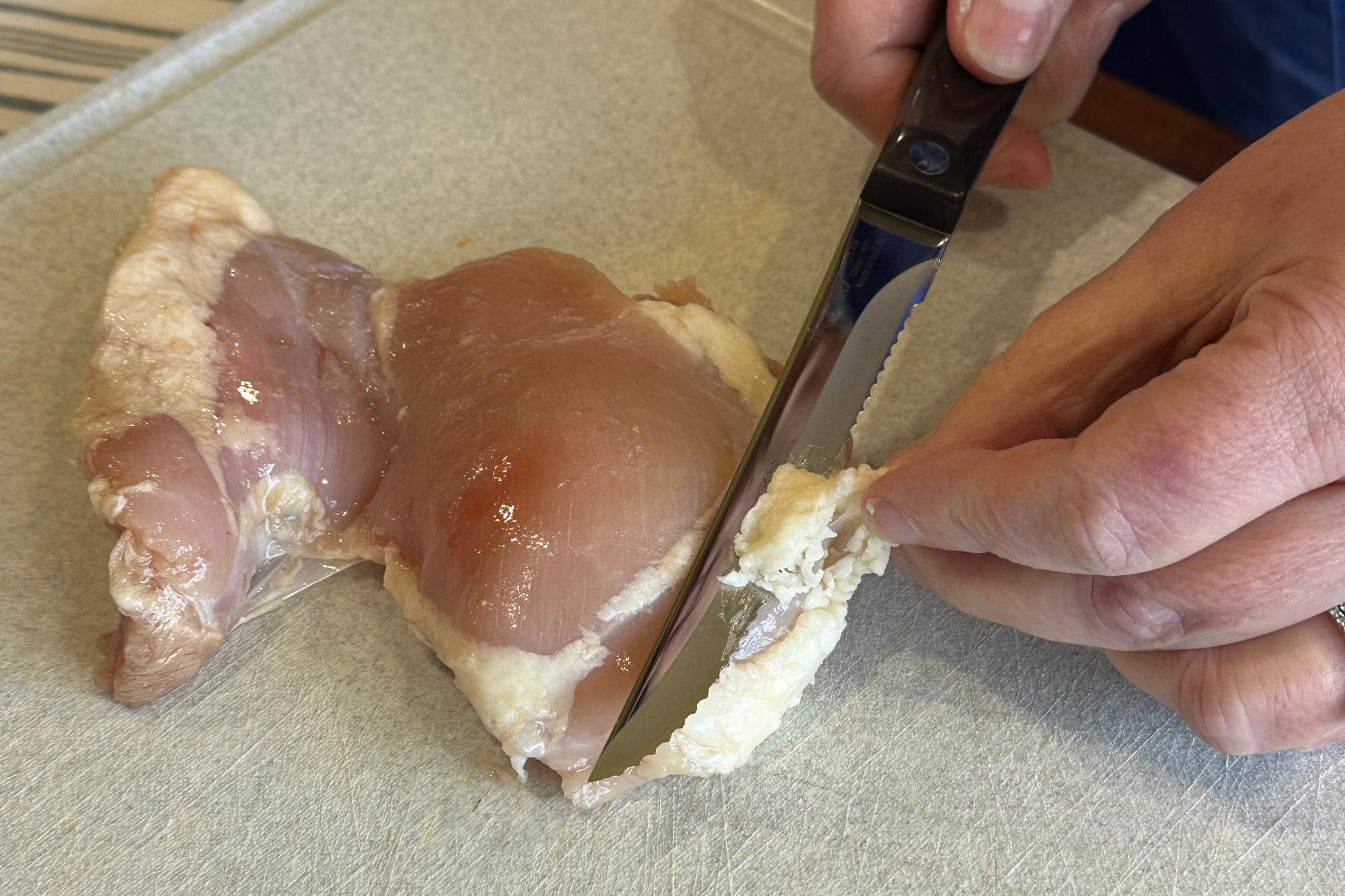 Slicing fat off chicken with a Trimmer.