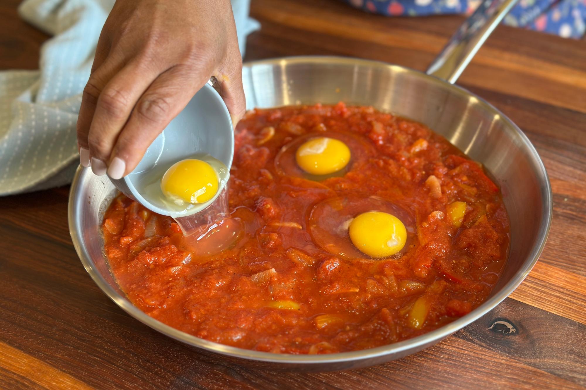 Adding eggs to sauce.