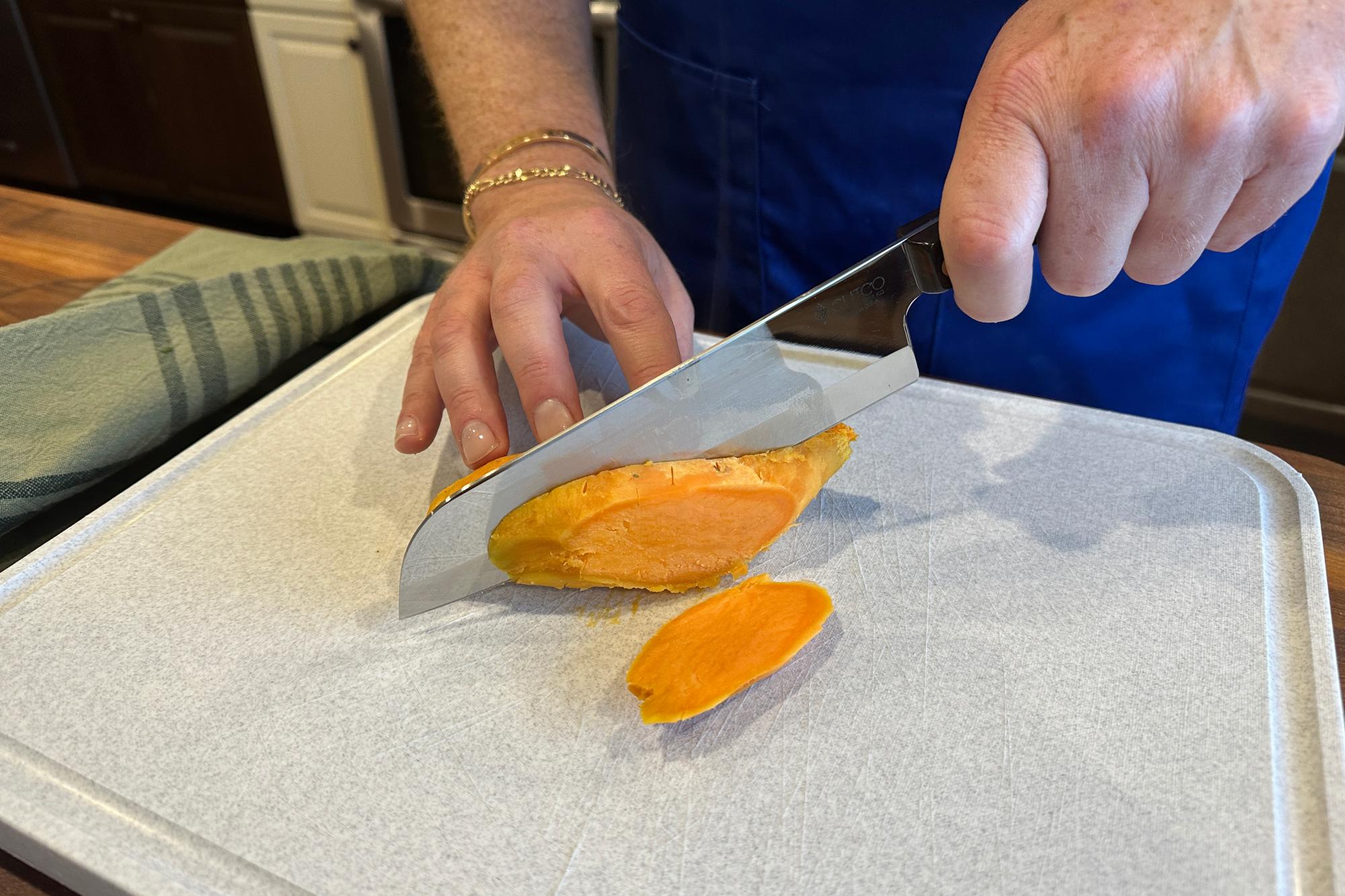 Cutting cooked sweet potatoes with a 7 Inch Santoku.