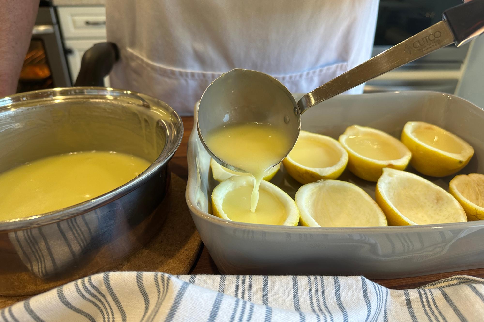 Pouring cream mixture into lemon shells.