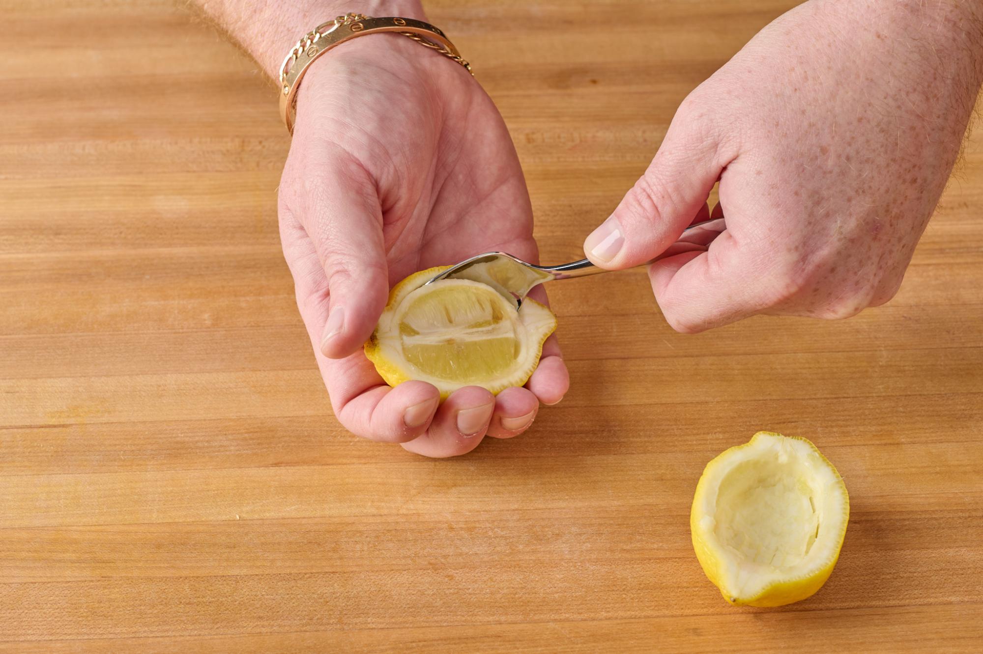 Removing flesh from lemon halves with Stainless Teaspoon