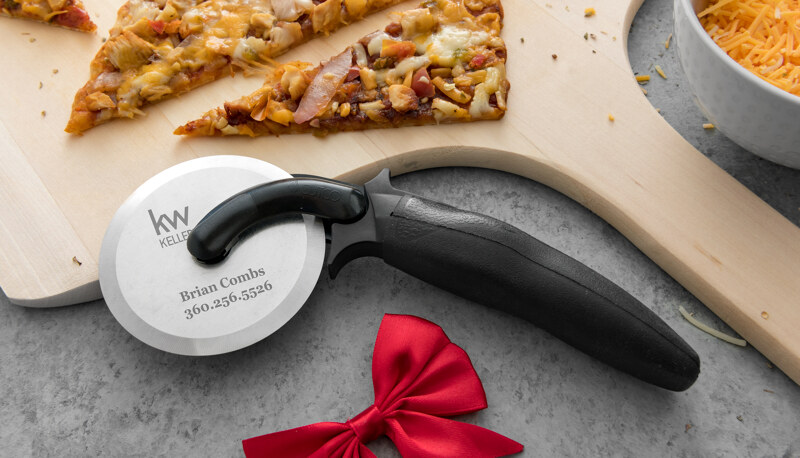 Closeup of Pizza Cutter in a home environment with business details engraved on metal.