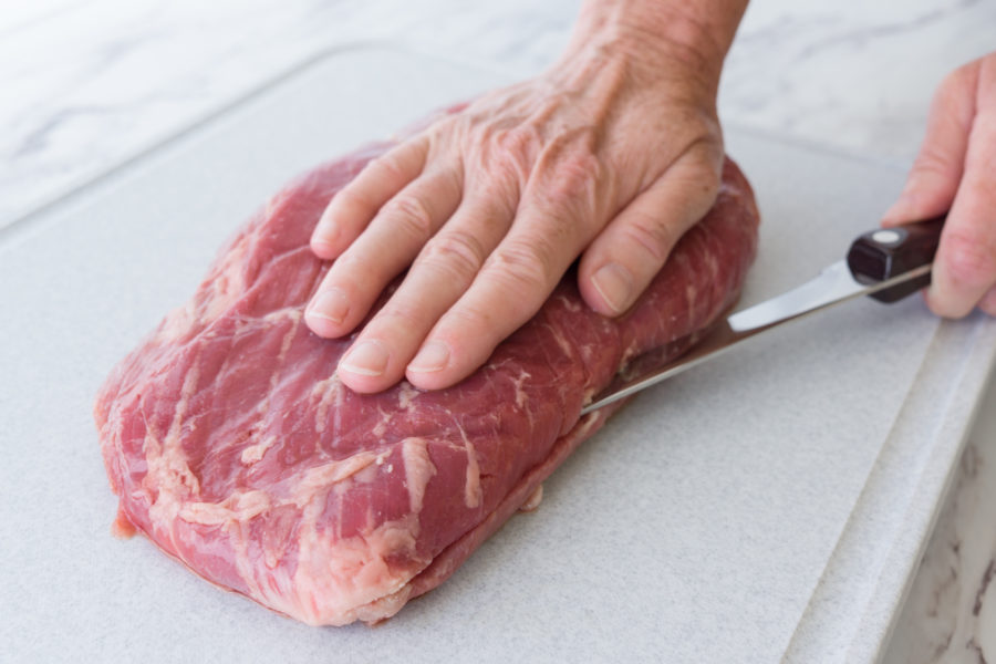 Using the boning knife to make an initial even cut in the flank.