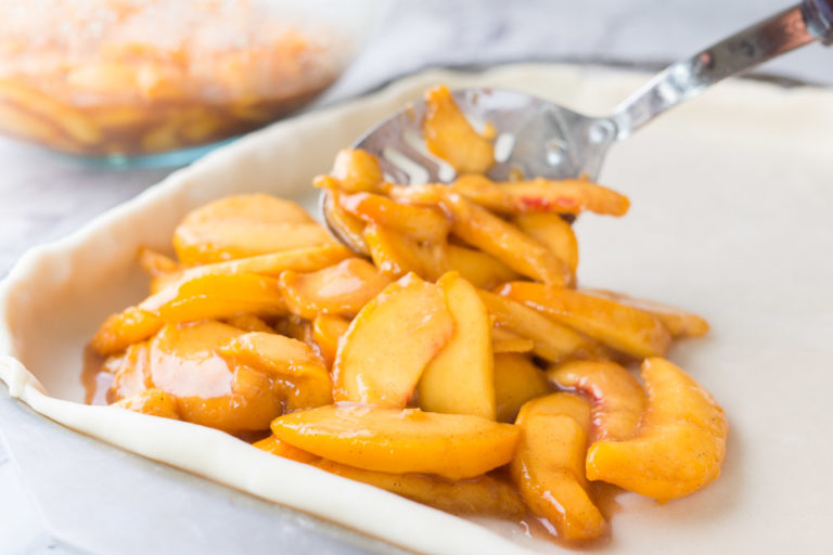 Scooping the peaches onto the dough.