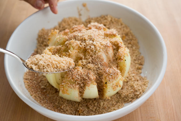 coating the onion with breadcrumbs.